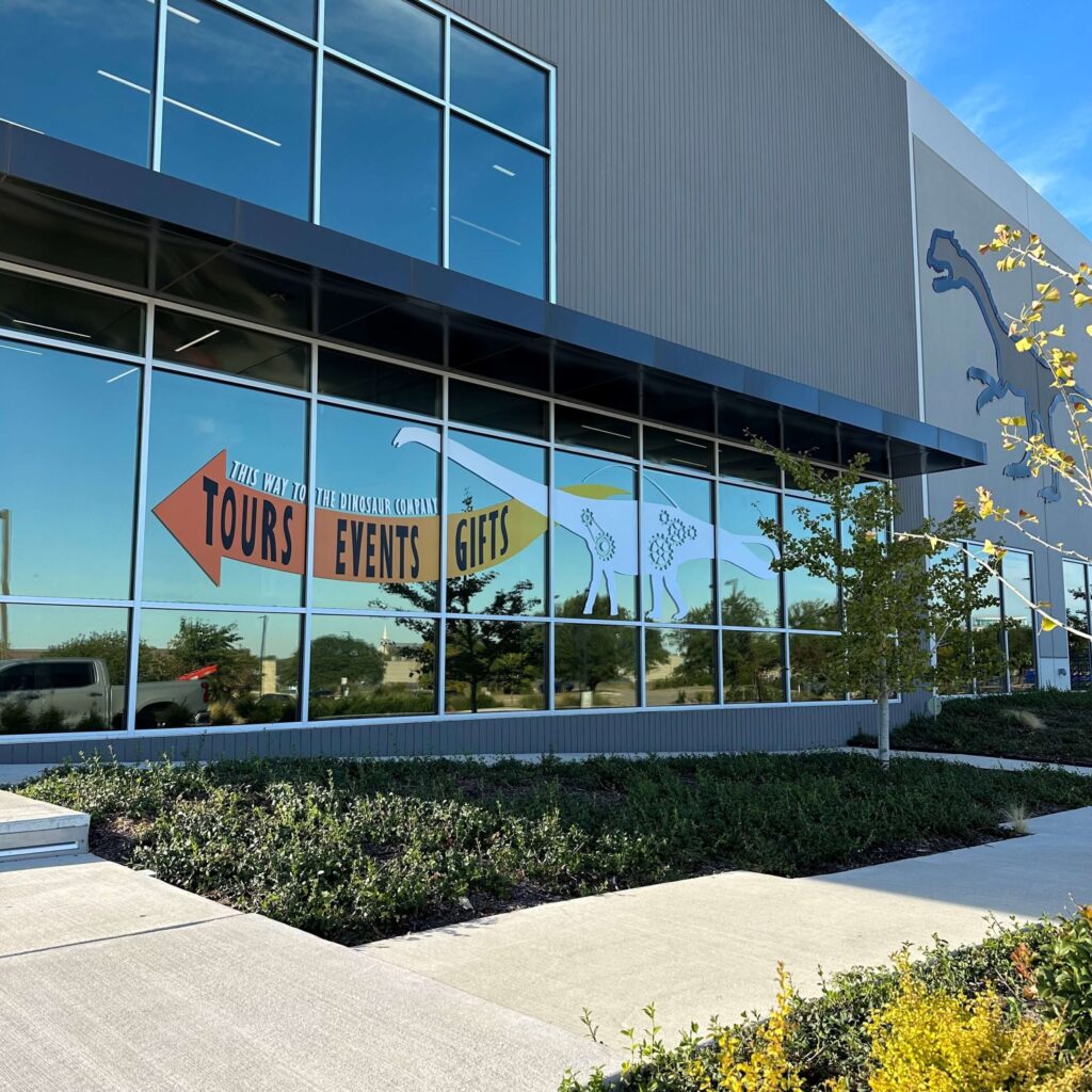 A building with glass wrap-around windows that have decal stickers on the side