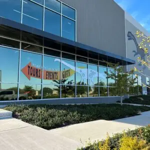 A building with glass wrap-around windows that have decal stickers on the side