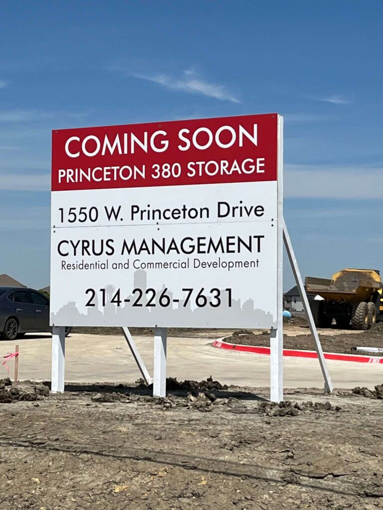 A large sign on a construction site that gives the contact info for Cyrus Management